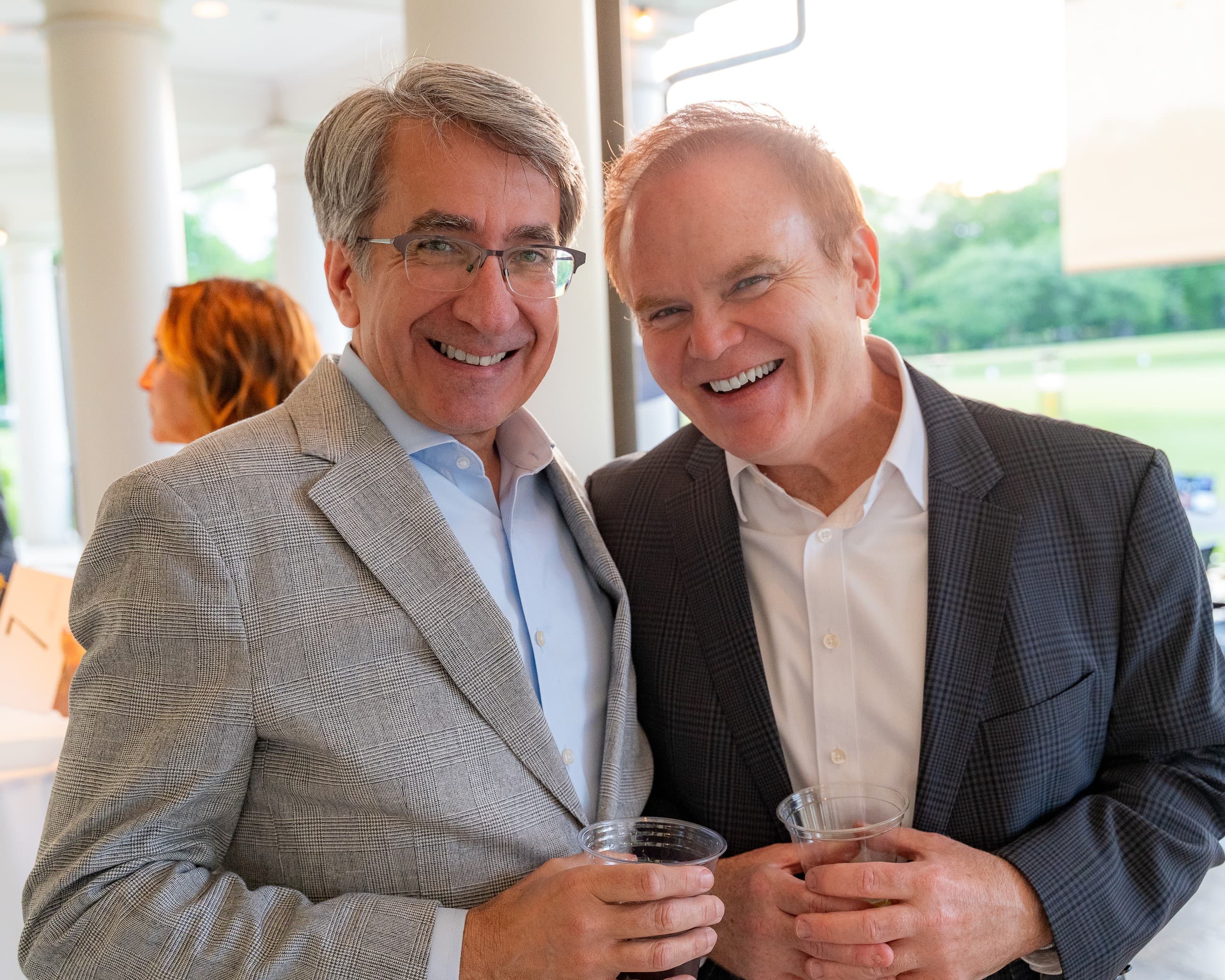 Two guests laughing together at a benefit dinner